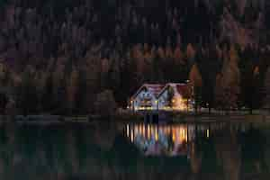 Free photo white and red house surrounded by trees at night