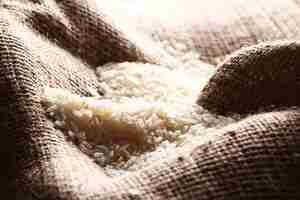 Free photo white rice grains on sack cloth