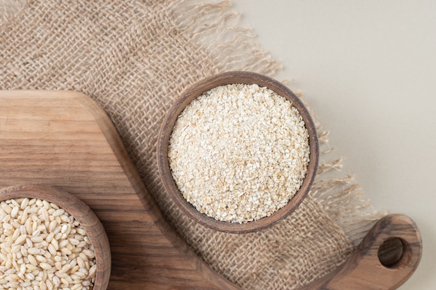 White rice in a wooden cup on a wooden platter.