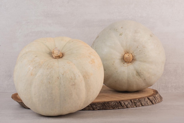 White ripe pumpkins on white table.