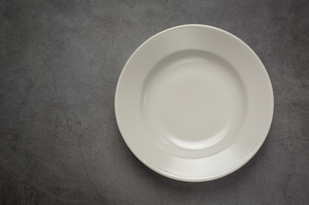 Free photo a white round empty  plate on dark surface