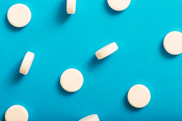 White round tablet medicine on blue background