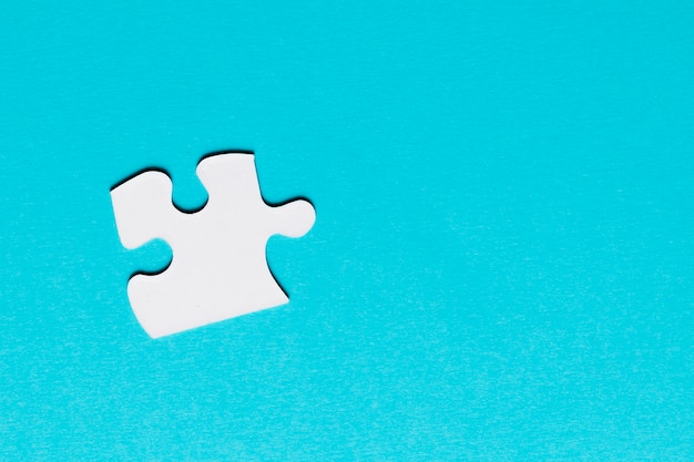 Free photo white single puzzle piece on blue background