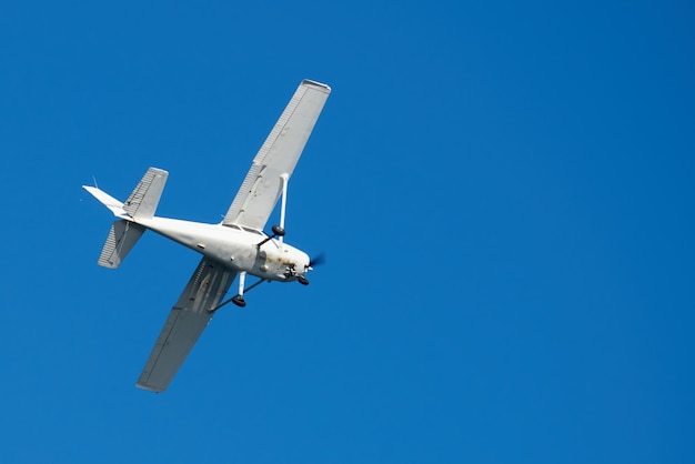 Free photo white small plane, rusted on bottom, making a turn in the sky in san diego