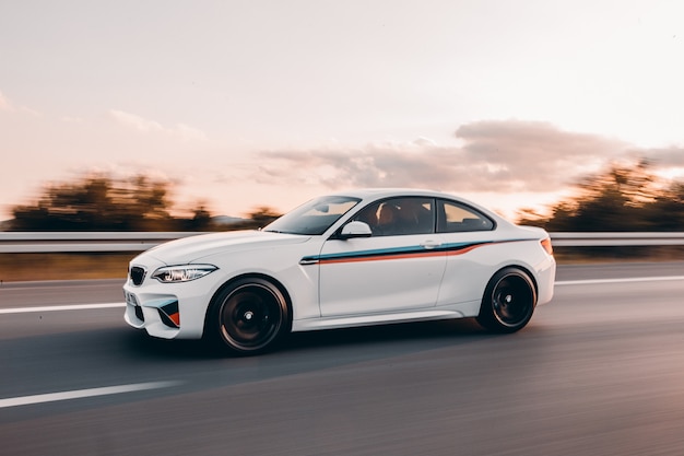 White sport sedan with colorful tuning on the road.