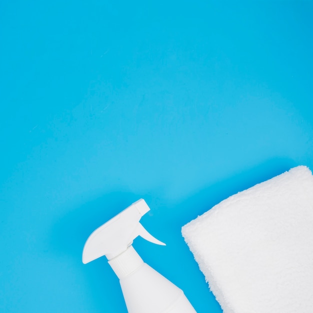 Free photo white spray bottle and sponge on blue background