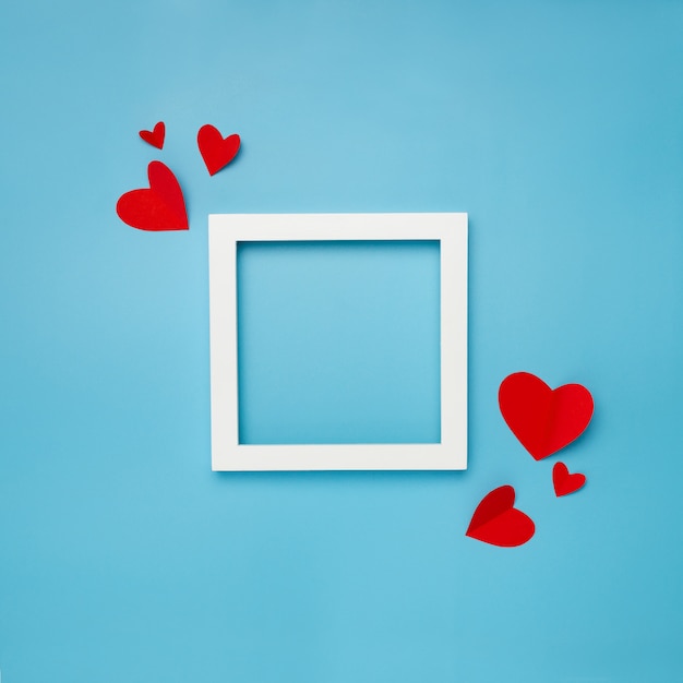 white square frame on blue background with paper hearts