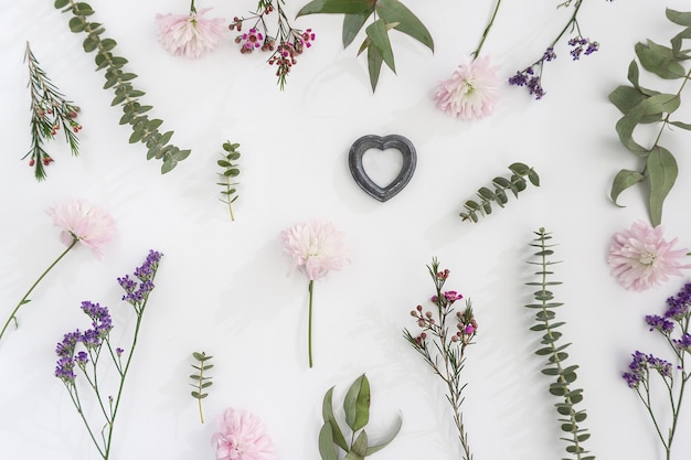 White surface with several flowers and romantic heart