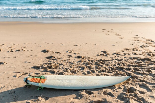 White surfboard lying on sand