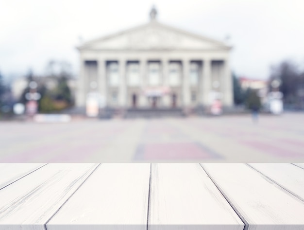 Free photo white texture desk in front of blur public building