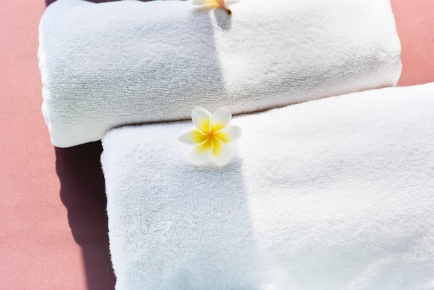 Free photo white towels decorated with plumeria flowers