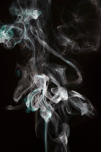 White and turquoise purple smoke waves isolated on black background