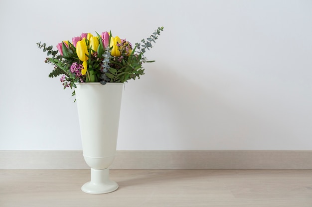 Free photo white vase with colored tulips