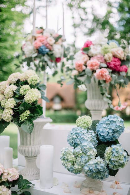 White vases with flowers stand outside