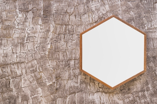 Free Photo white wooden hexagon frame on painted wall