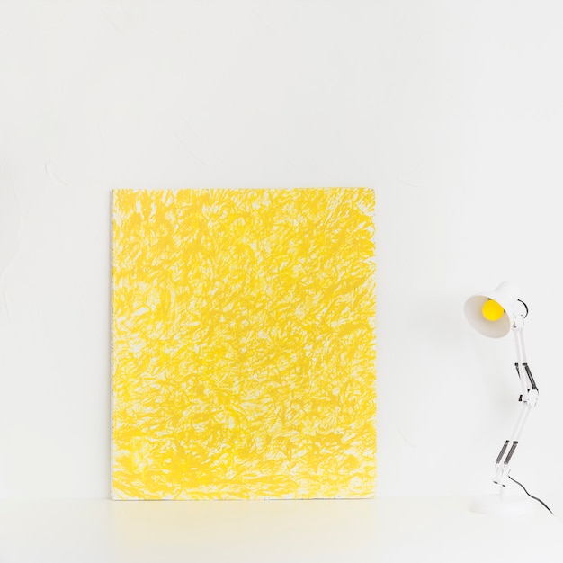 Free Photo white workspace with yellow picture and reading lamp