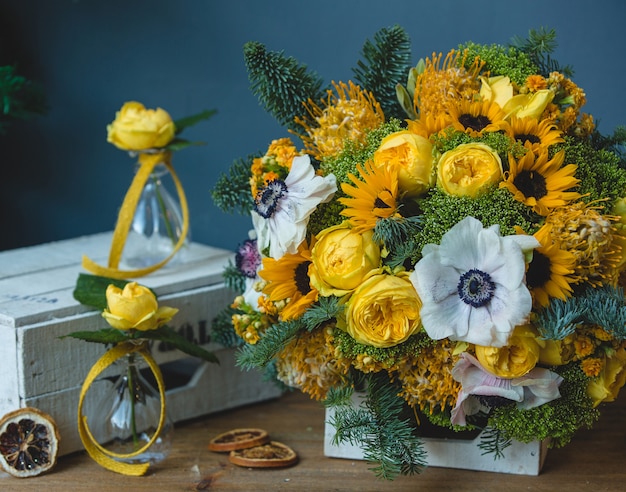 White yellow flower bouquet and small flask vases around