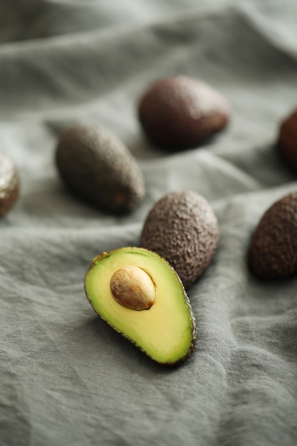 Free Photo whole and cut avocados on gray cloth