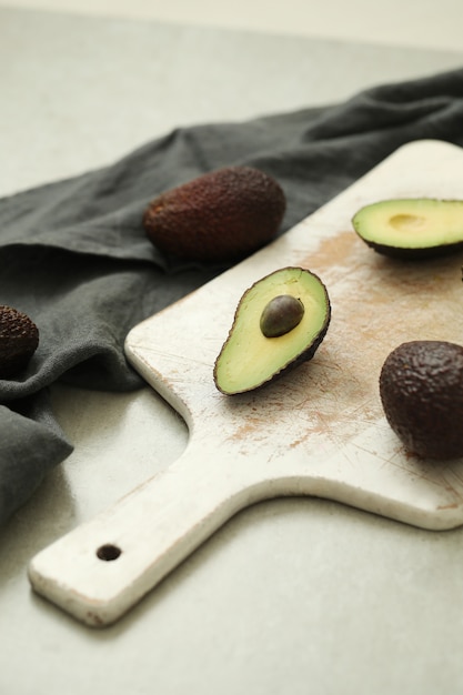 Free Photo whole and cut avocados on wooden cutting board