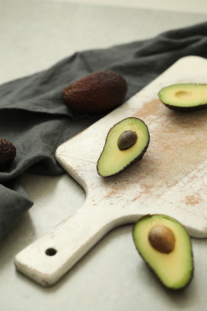 Free Photo whole and cut avocados on wooden cutting board