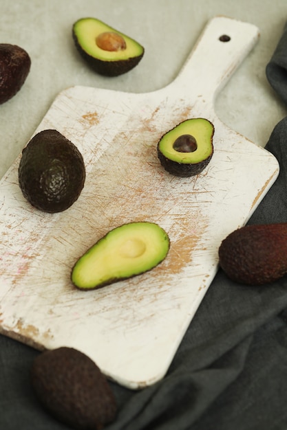 Free Photo whole and cut avocados on wooden cutting board