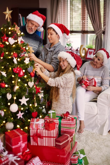 Whole family dressing a christmas tree