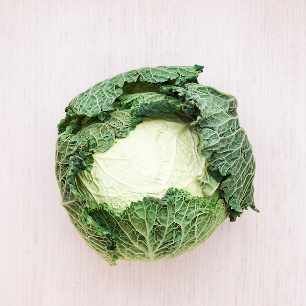 Free photo whole fresh savoy cabbage on wooden surface