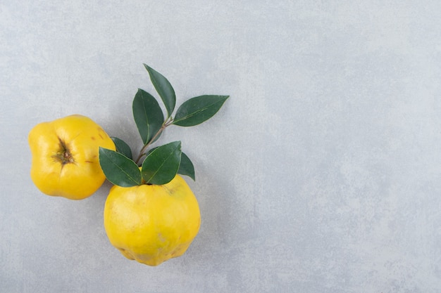 Free photo whole ripe quinces on stone surface