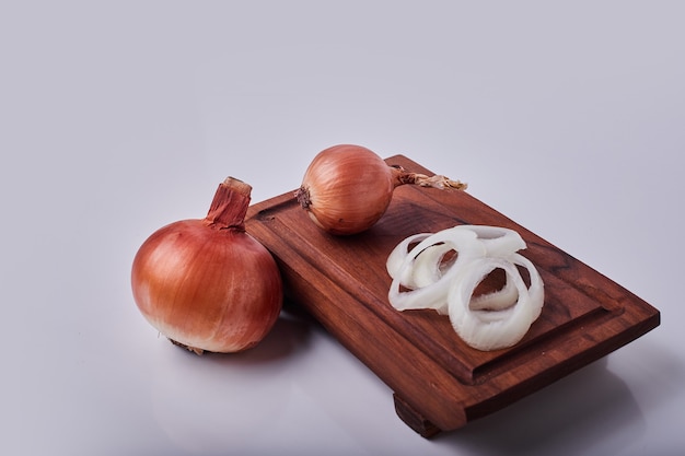 Free Photo whole and sliced onions on a wooden board