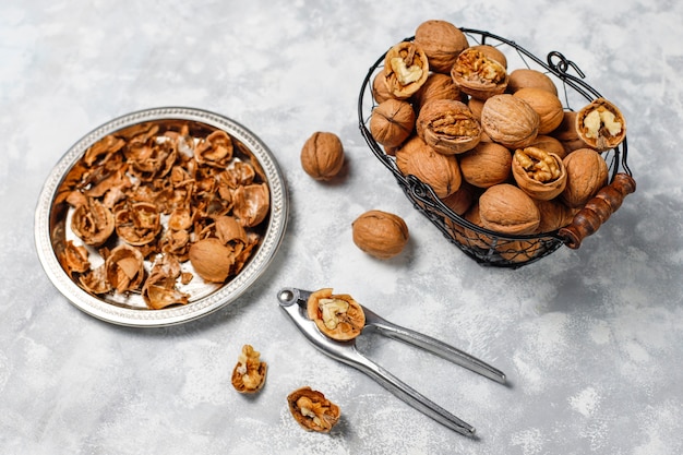 Free photo whole walnuts in shell in food metal basket, walnut kernels. top view on concrete