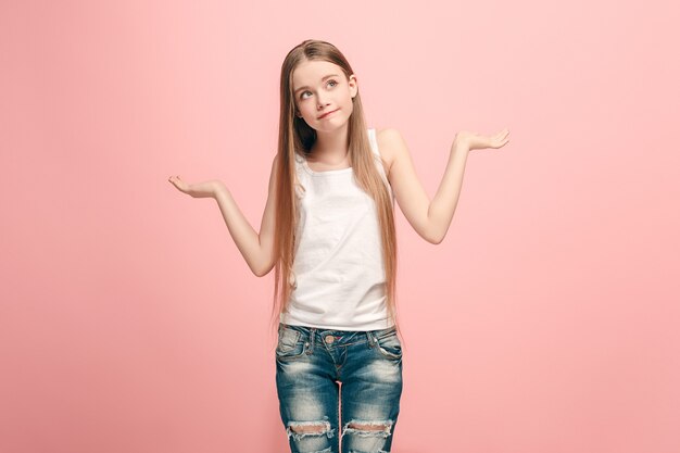 Why is that. Beautiful female half-length portrait on trendy pink  wall. Young emotional surprised, frustrated and bewildered teen girl. Human emotions, facial expression concept.