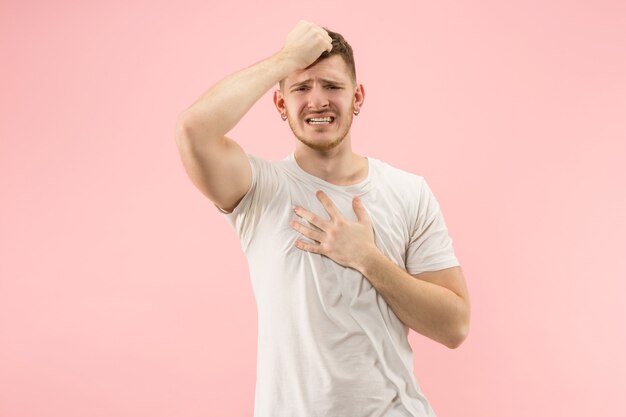 Why is that. Beautiful male half-length portrait isolated on trendy pink studio backgroud. Young emotional surprised, frustrated and bewildered man. Human emotions, facial expression concept.