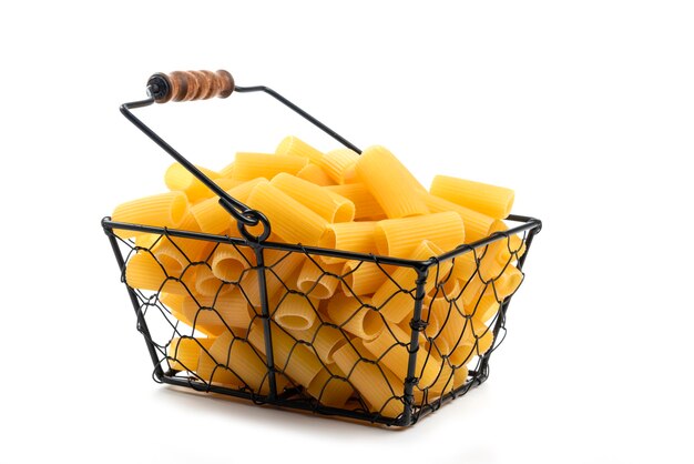 Wicker basket of raw tube pasta isolated on white.