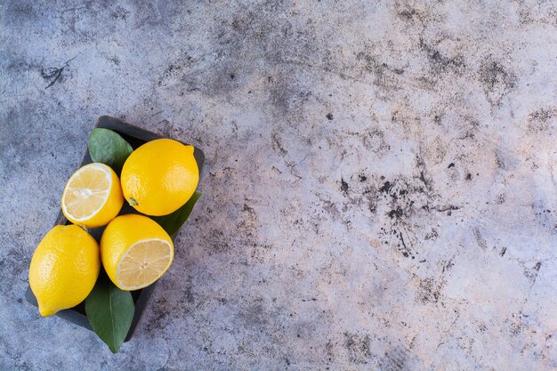 Wide angle photo of organic lemons on grey.