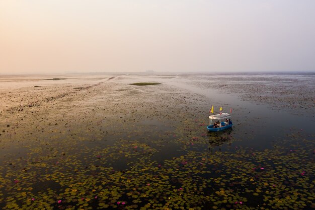 Wide angle shot of a boat in the Lotus Lake in Thailand