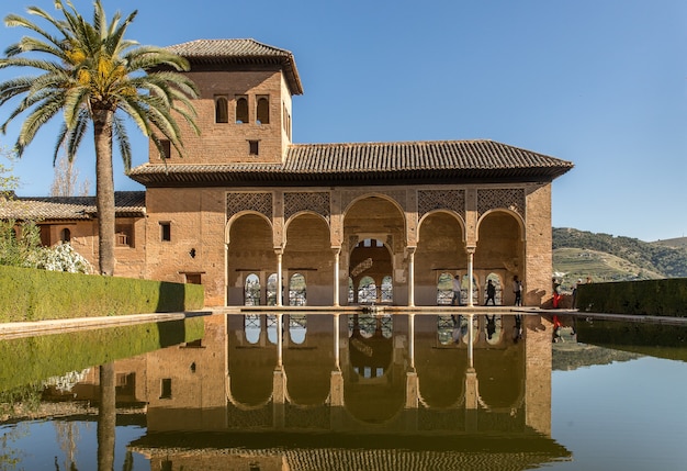 Wide angle shot of a building in front of the water and next to the tree in Spain