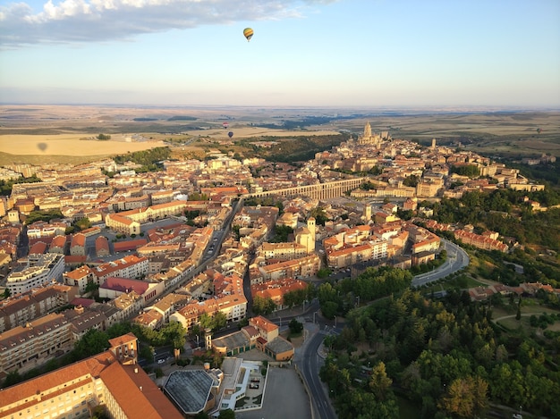 Free Photo wide angle shot of many buildings surrounded by trees and a parachute up in the air