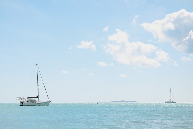 Free photo wide angle shot of an ocean with boats on top under a clear sky,