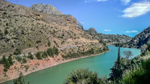 Wide angle shot of a river flowing next to the mountains during daytime