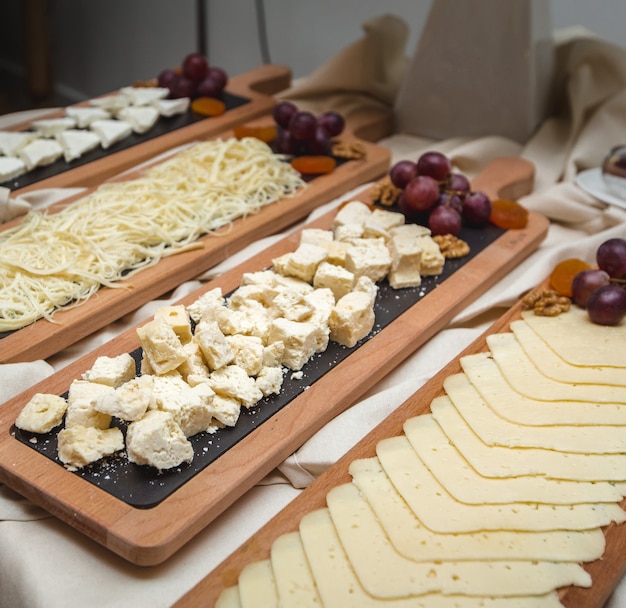 Free photo a wide selection of cheese platters with fresh grapes on the table.