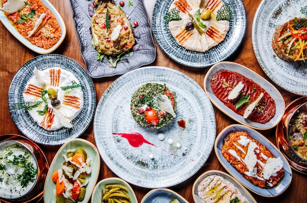 Wide selection of eastern, oriental foods in rustic plates on the table.