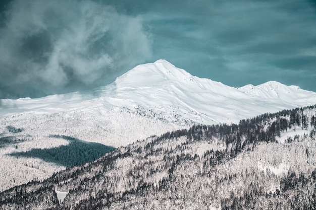 Wide shot of the beautiful snow covered mountains under the cloudy sky