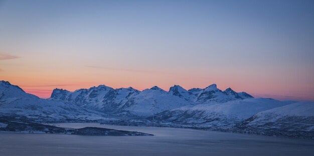 Wide shot of the breathtaking snow covered mountains captured in Tromso, Norway