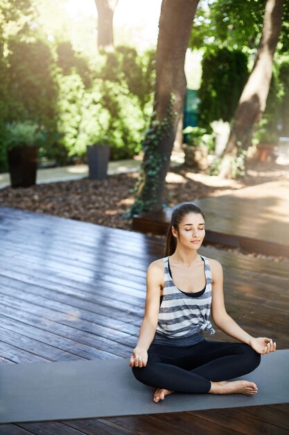 Wide shot of female yogi meditating in a modern urban yoga temple Negative space