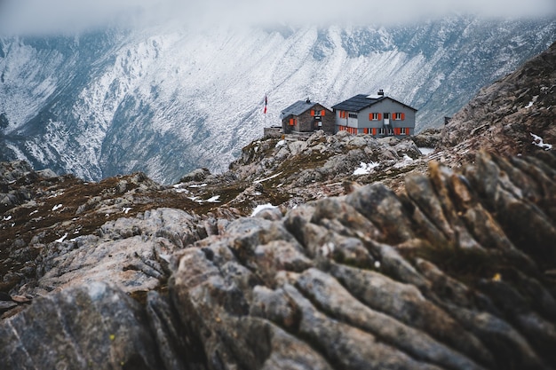 Free photo wide shot of a house isolated on the mountains covered by snow in capanna cadlino