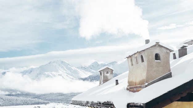 Free photo wide shot of a house near mountains covered in snow