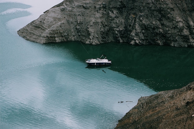 Free Photo wide shot of a motorboat on the body of water in the middle of mountains