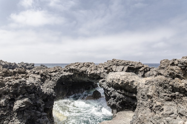 Free photo wide shot of rock formations on the body of water under sky