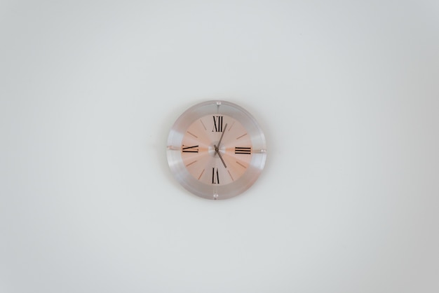 Free Photo wide shot of a rose gold wall clock on a white wall