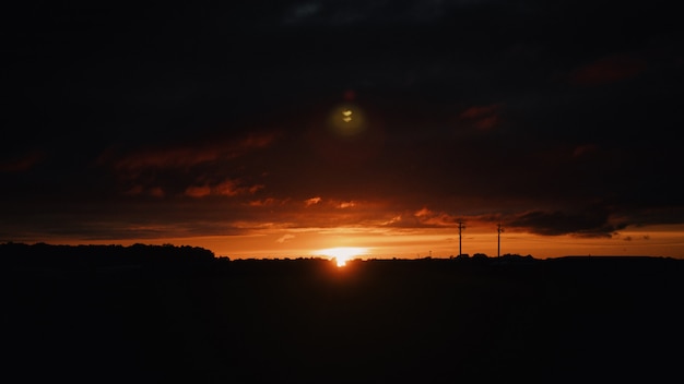 Free photo wide shot of the silhouettes of hills in the countryside at sunset